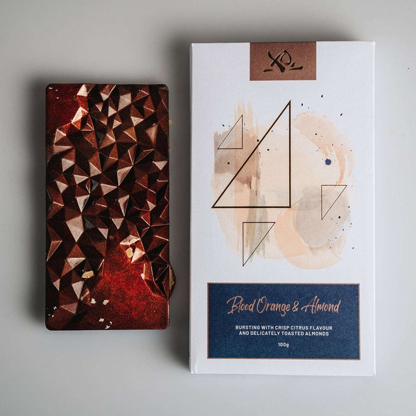Dark chocolate bar with orange and almond white background and chocolate bar packaging